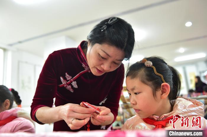 江西省級非遺豫章繡傳承人手把手指導(dǎo)小學(xué)生繡制2022年北京冬奧會吉祥物“冰墩墩”形象?！∮髟屏?攝