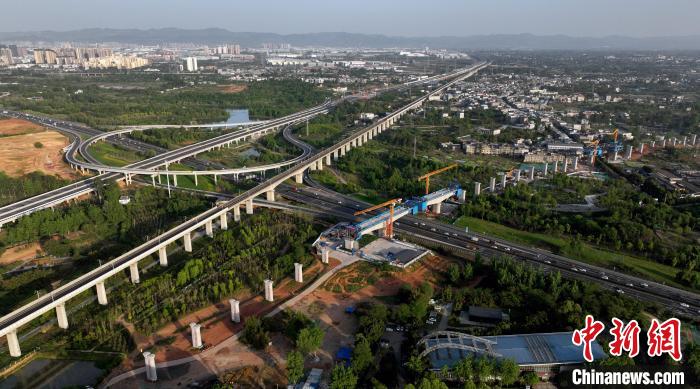航拍正在建設(shè)的跨越成都繞城高速公路連續(xù)梁施工現(xiàn)場，旁邊依次為已運營的成渝高速鐵路和機場高速公路?！⒅铱?攝