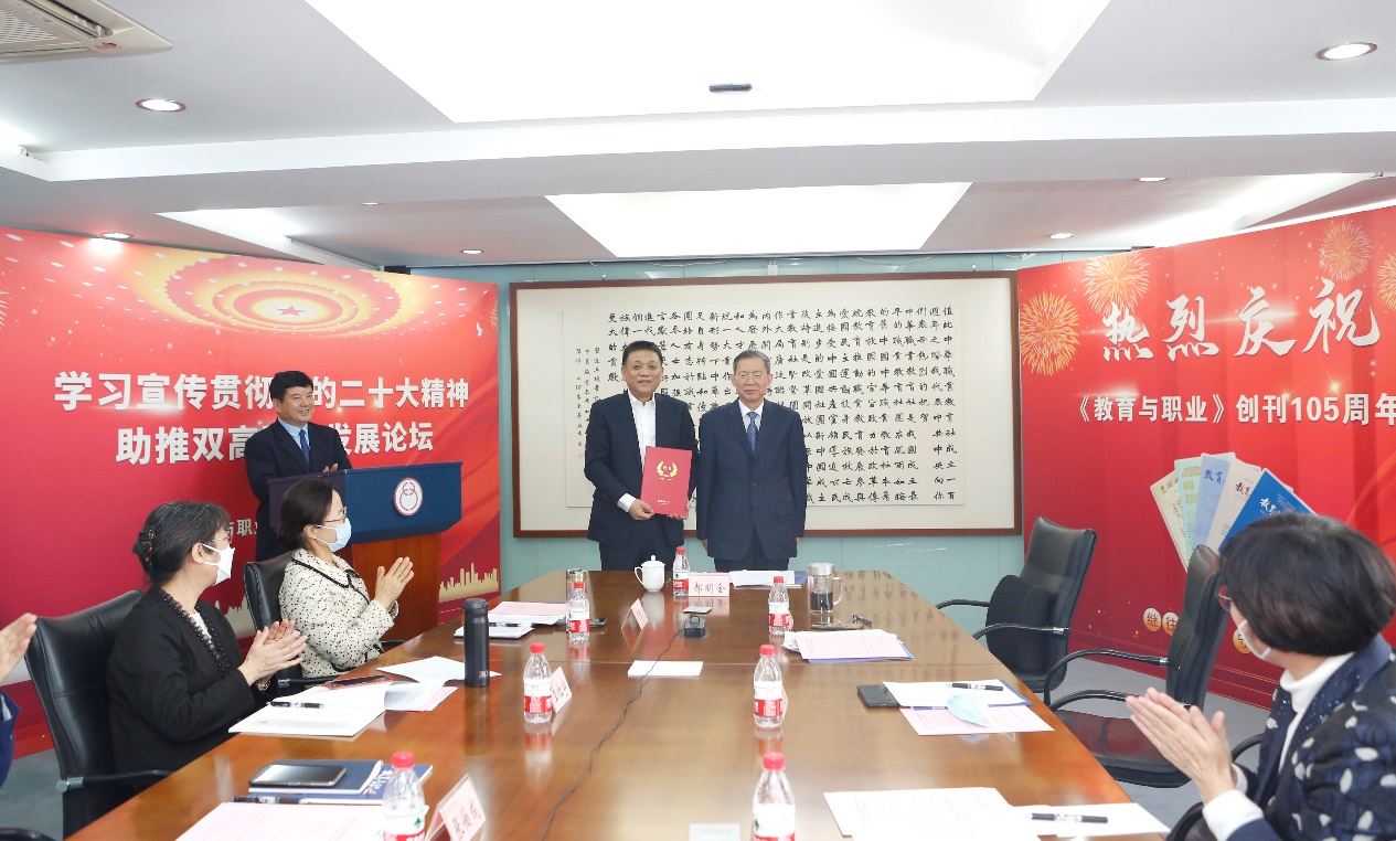 郝明金為《教育與職業(yè)》雜志編委代表陳曉明頒發(fā)聘書。中華職教社供圖
