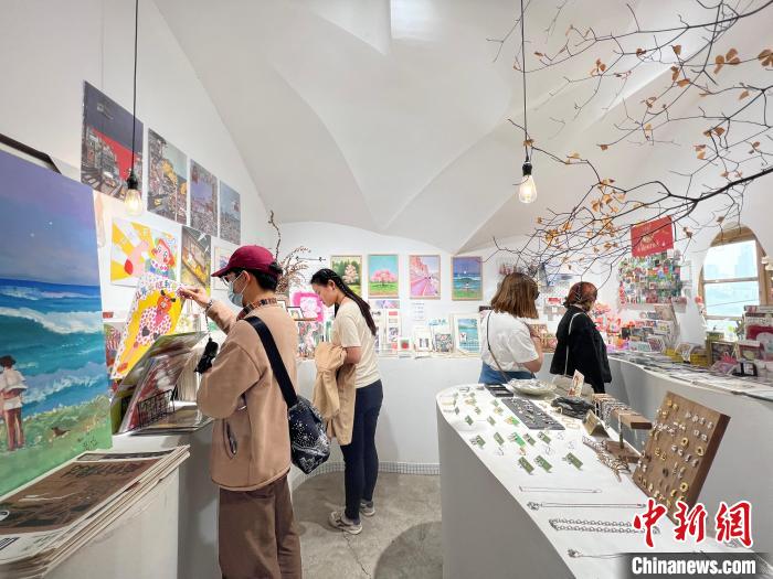 圖為藝術(shù)品商店內(nèi)，顧客挑選插畫作品。　鐘旖 攝