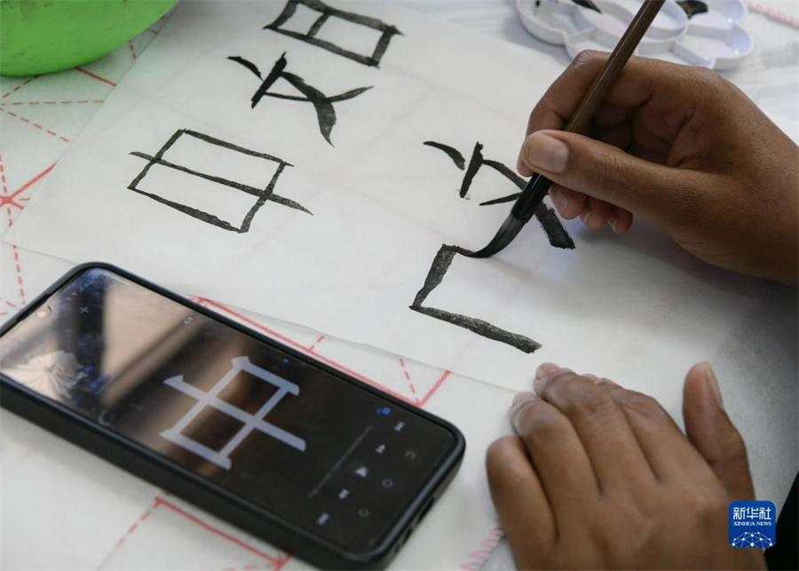 4月18日，肯尼亞學(xué)生在內(nèi)羅畢大學(xué)孔子學(xué)院舉辦的活動(dòng)上寫毛筆字?？夏醽唭?nèi)羅畢大學(xué)孔子學(xué)院18日舉辦“中文，增進(jìn)文明對(duì)話”主題活動(dòng)，慶祝即將到來(lái)的第14個(gè)聯(lián)合國(guó)中文日?？夏醽唽W(xué)生參與互動(dòng)，進(jìn)行書法、剪紙、唱中文歌等活動(dòng)。新華社記者 韓旭 攝