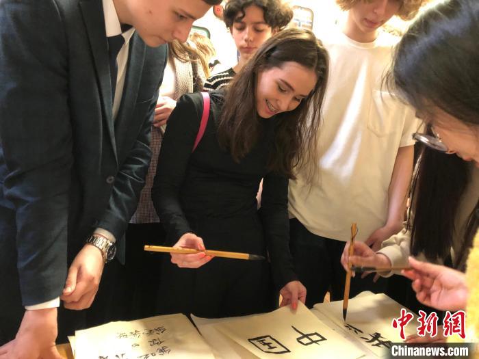 4月21日，莫斯科國(guó)立語言大學(xué)孔子學(xué)院附屬中學(xué)舉辦“國(guó)際中文日”活動(dòng)，學(xué)生們學(xué)寫漢字?！∧箍茋?guó)立語言大學(xué)孔子學(xué)院 供圖