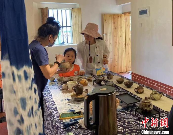 圖為：游客正在咨詢臺灣柴燒作品?！∪~秋云 攝