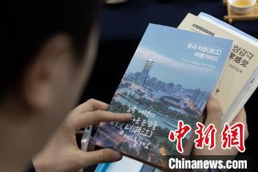 參展觀眾閱讀浙江文旅手冊?！《≌裾?攝
