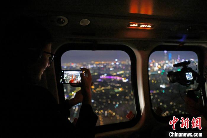 6月3日晚，游客乘坐上海新空直升機(jī)有限公司直升機(jī)開啟鳥瞰黃浦江空中圓夢(mèng)之旅，并用手機(jī)拍攝城市夜景?！∫罅⑶?攝