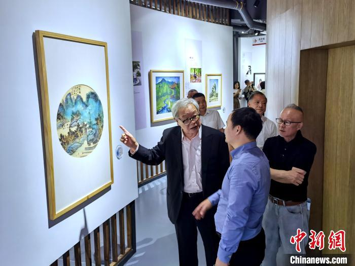 海峽兩岸藝術(shù)家畫展上，藝術(shù)家進(jìn)行藝術(shù)交流?！「毒窜?攝