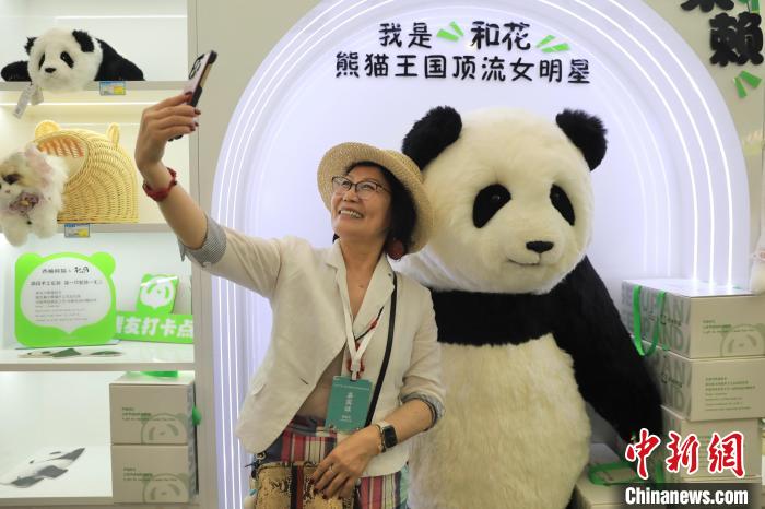 美國華視總裁楊蓮花與大熊貓文創(chuàng)產品合影?！⊥趵?攝