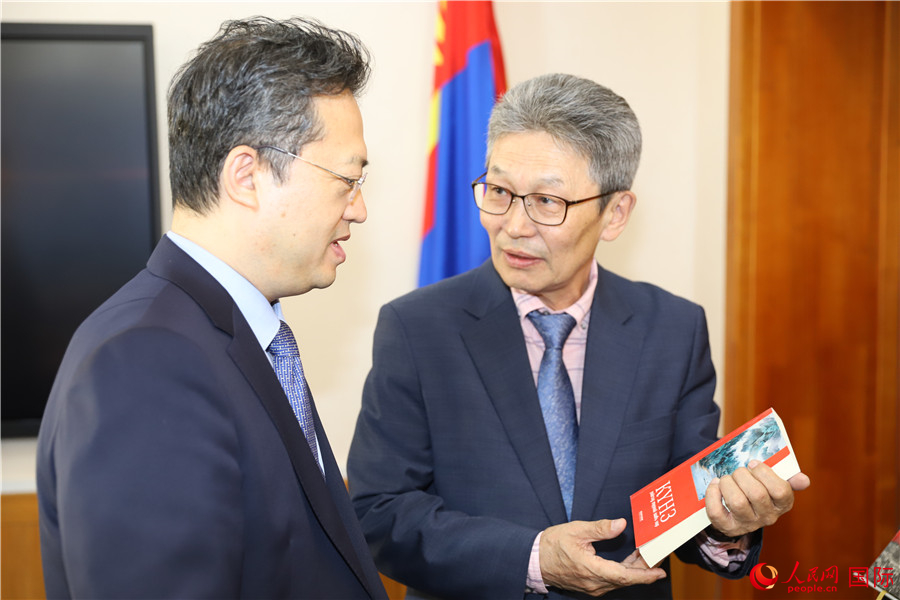 其米德策耶（右一）向李峙介紹翻譯成果。人民網(wǎng)記者 霍文攝