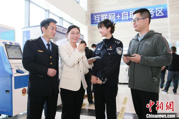 4月10日，安徽合肥，一家運輸企業(yè)負責人在工作人員的指導下，使用小程序辦理車管業(yè)務?！『戏示焦﹫D