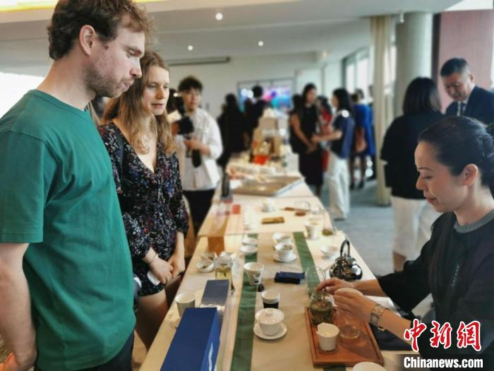 現(xiàn)場(chǎng)觀眾觀看中國展臺(tái)茶藝表演、了解茶文化?！【笜?攝