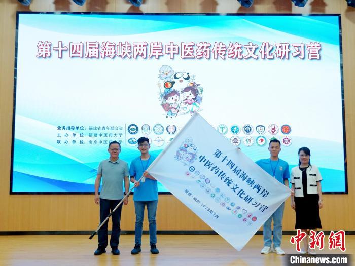 共青團(tuán)福建省委副書記吳雪(右一)、福建中醫(yī)藥大學(xué)黨委副書記林羽(左一)為兩岸學(xué)生代表頒授營(yíng)旗。　許燁婷 攝