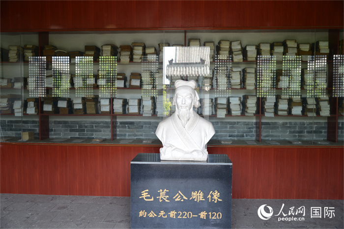 河間詩(shī)經(jīng)齋毛萇雕像。雕像后書(shū)櫥中陳列的是歷代各版本《詩(shī)經(jīng)》及譯本。 人民網(wǎng) 趙昭攝