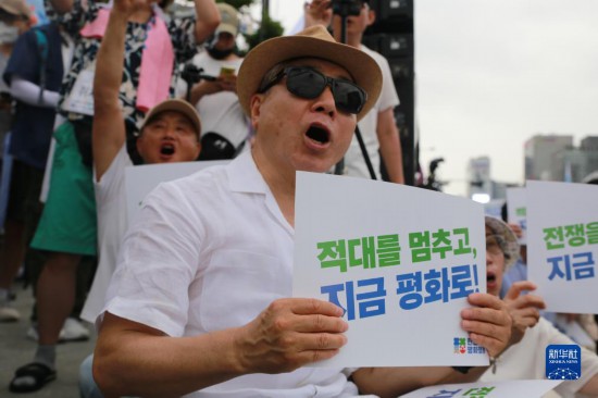 7月22日，在韓國(guó)首爾，人們手舉標(biāo)語(yǔ)參與反戰(zhàn)游行。新華社發(fā)（楊暢 攝）