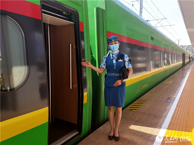 趙瑩靜站在“復(fù)興號”國際旅客列車車廂門口歡迎旅客上車。人民網(wǎng) 杜明明攝