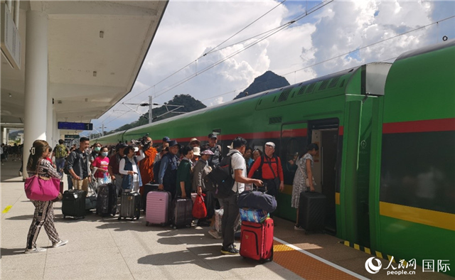 乘坐中老鐵路國際旅客列車的旅客在老撾瑯勃拉邦站排隊上車。人民網(wǎng)記者 杜明明攝