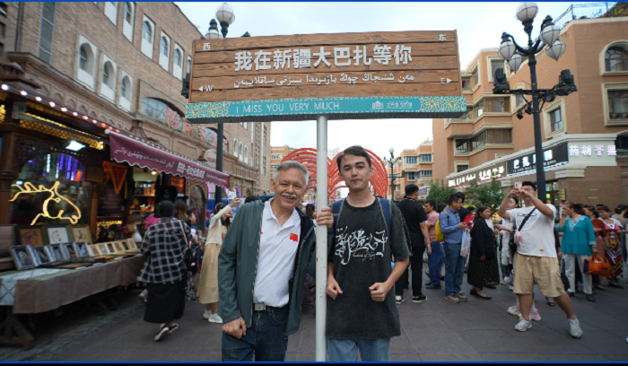 潘維廉和維吾爾族青年伊木蘭“打卡”大巴扎。主辦方供圖