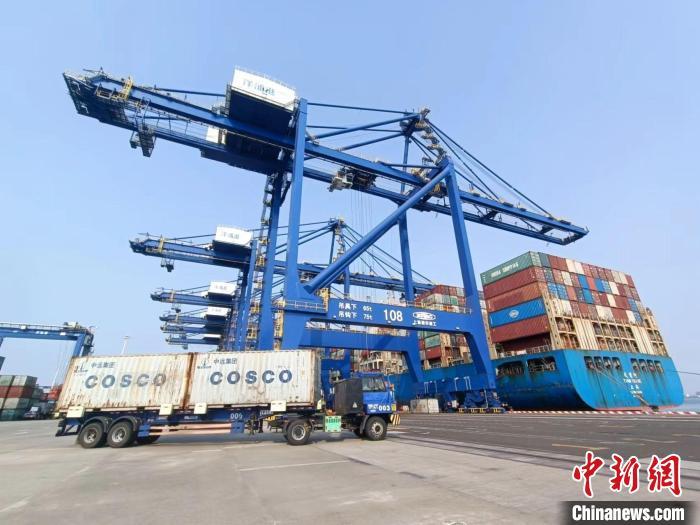 圖為海南洋浦國際集裝箱碼頭，卡車將集裝箱從后方堆場運往碼頭裝卸區(qū)?！堅潞?攝