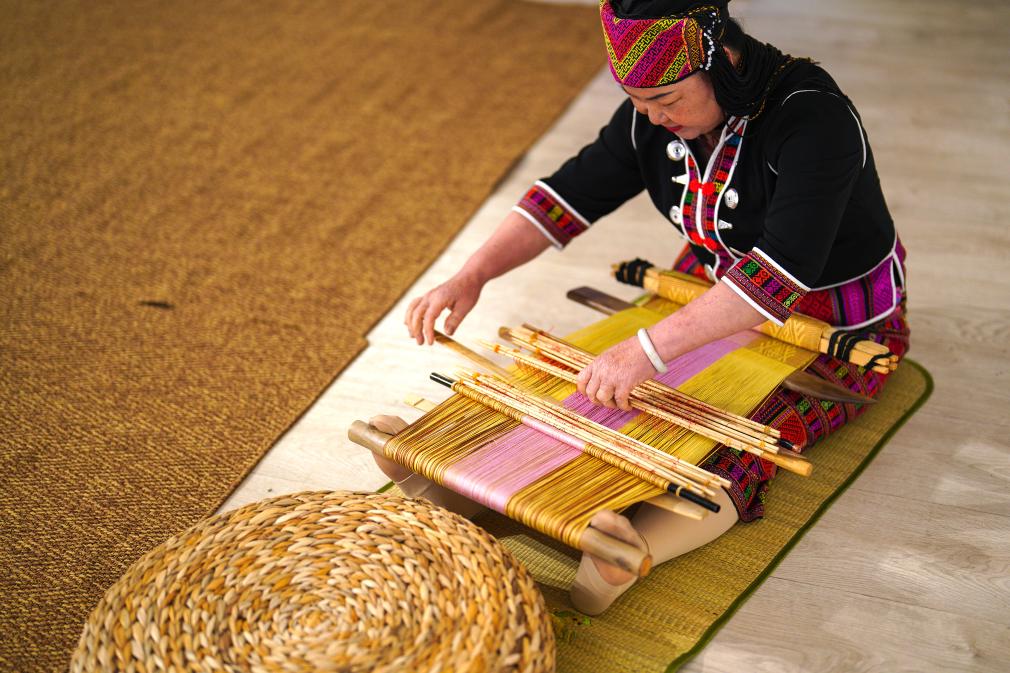 4月17日，黎族傳統(tǒng)紡染織繡技藝國家級(jí)代表性傳承人劉香蘭在2023年意大利米蘭設(shè)計(jì)周上展示黎錦織造技藝。新華社發(fā)