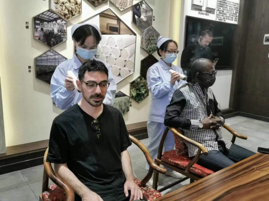 2023“一帶一路”媒體合作論壇聯(lián)合采訪團(tuán)團(tuán)員在九牛草展示館體驗(yàn)艾灸。（本報(bào)記者 黃超攝）
