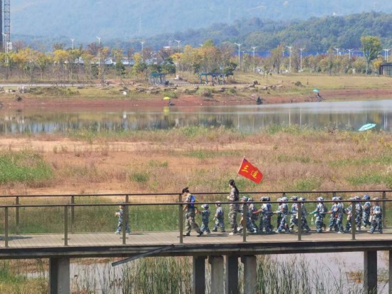 　　10月24日，秋游的幼兒園小朋友在老師帶領(lǐng)下走在清水塘公園里的木橋上。本報(bào)記者 常雯宜攝