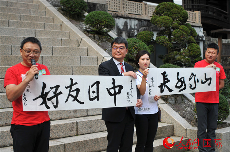 東京中國(guó)文化中心主任羅玉泉展示其為本次活動(dòng)書寫的題詞“中日友好，山高水長(zhǎng)”。人民網(wǎng) 蔣曉辰攝