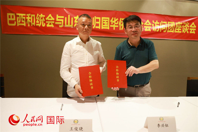 中國僑聯(lián)副主席、山東省僑聯(lián)主席李興鈺（右）與巴西和統(tǒng)會(huì)會(huì)長王俊曉簽署合作協(xié)議書。人民網(wǎng)記者 陳海琪攝