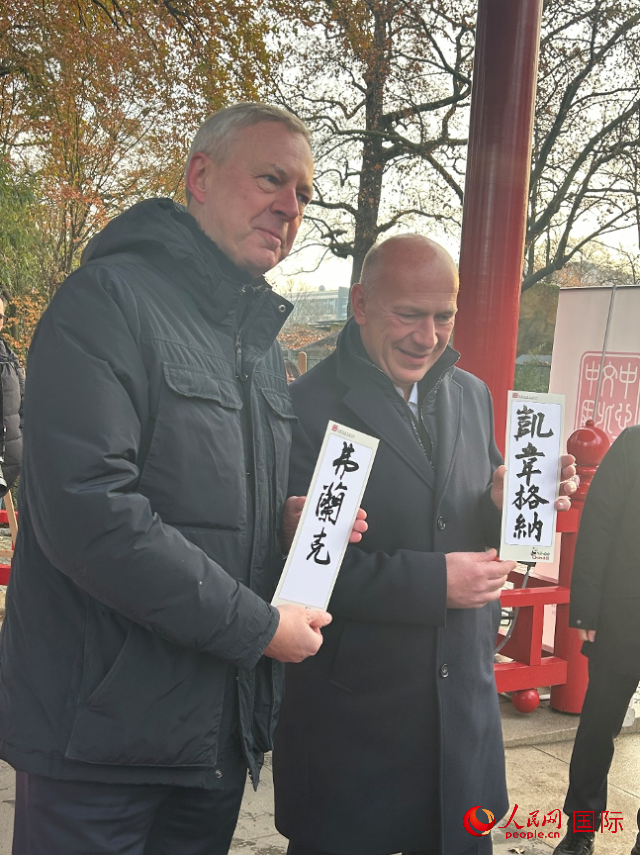 柏林市長韋格納（右）、動物園監(jiān)事會主席布魯克曼（左）手持中國文化中心工作人員現(xiàn)場手書的中文名字。人民網(wǎng)記者 徐馨攝