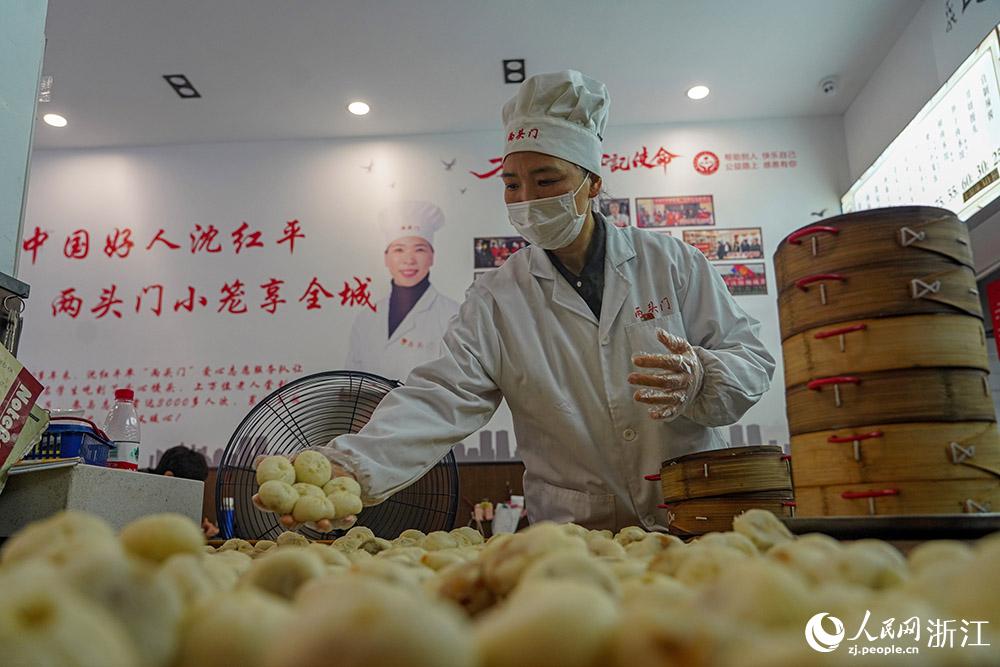 3月31日，在浙江省嵊州市甘霖鎮(zhèn)，嵊州小吃從業(yè)者沈紅平把蒸熟的小籠包晾涼，打包冷藏售賣。人民網(wǎng) 章勇濤攝