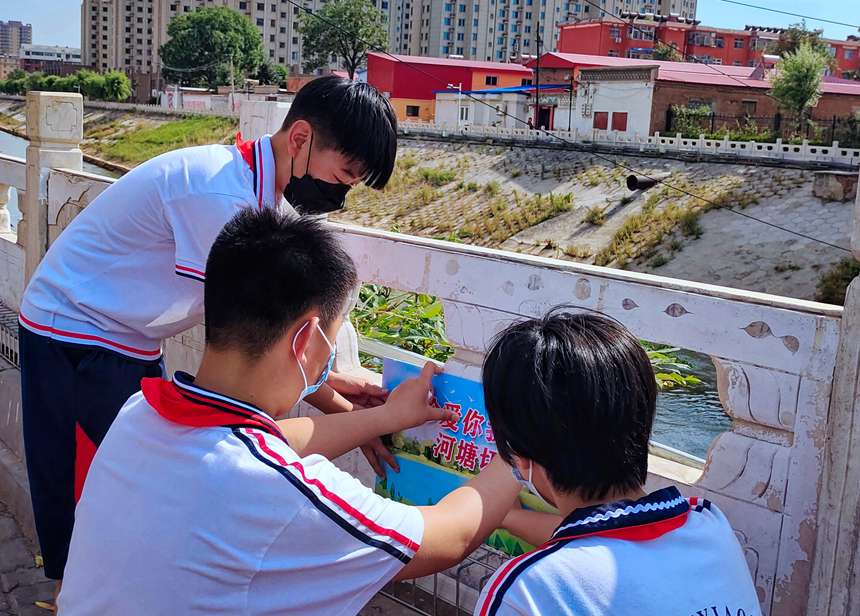 徐水小學(xué)學(xué)雷鋒志愿者在瀑河河邊張貼防溺水警示標(biāo)語。 徐水區(qū)委宣傳部供圖