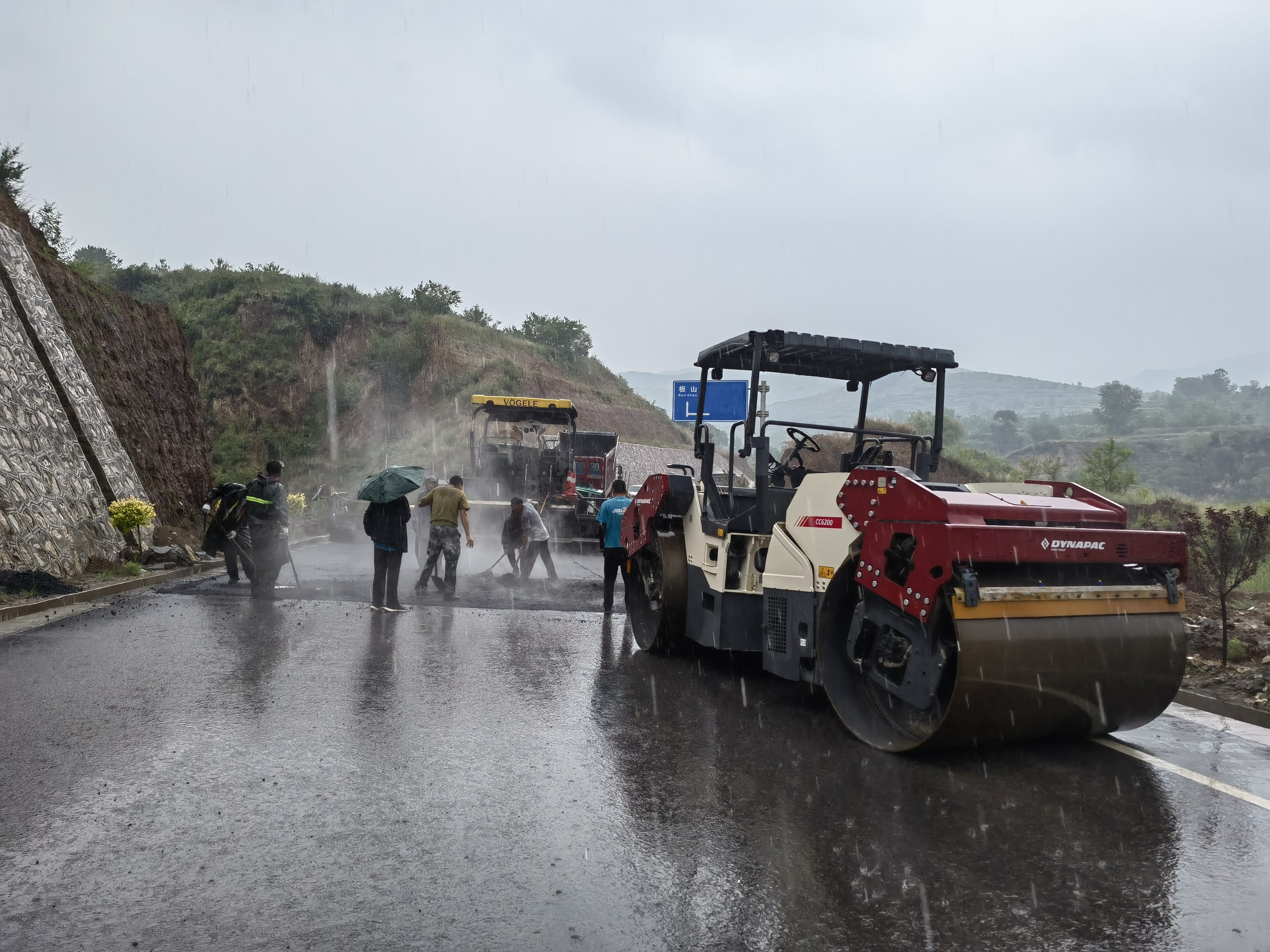路橋工人在大雨中搶修道路。李華英 攝