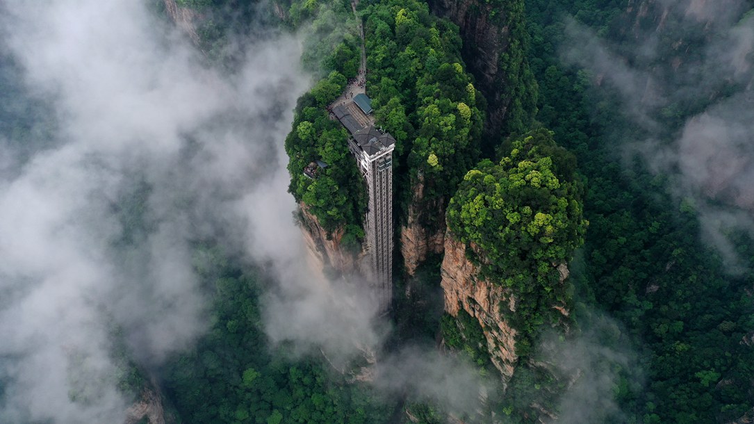 位于張家界武陵源景區(qū)的百龍?zhí)焯蓁偳对谠旗F繚繞的峰林間，雄偉壯觀。吳勇兵攝