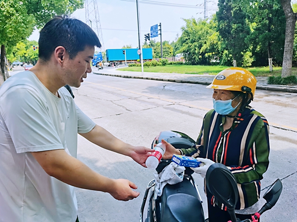 何超為過路的老人送上礦泉水和冷飲。人民網(wǎng)記者 王繼亮攝