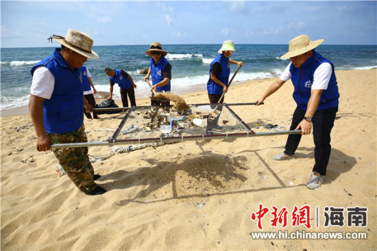 環(huán)保志愿者用篩網(wǎng)“淘”出海灘上的垃圾。