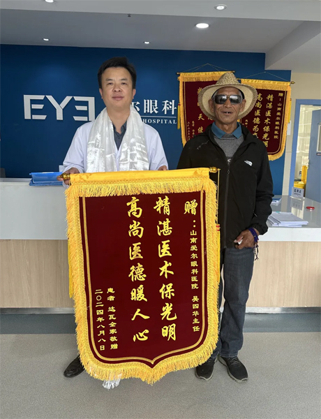 達(dá)瓦老人向吳四華（左）贈(zèng)送錦旗。受訪者供圖