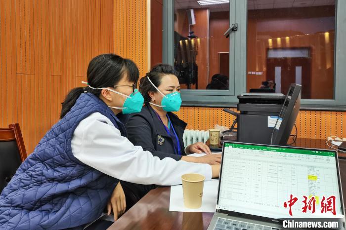 8月9日，楊蘇喬(左)在拉薩方艙醫(yī)院指揮部讀取艙內(nèi)患者胸部CT。　受訪者供圖
