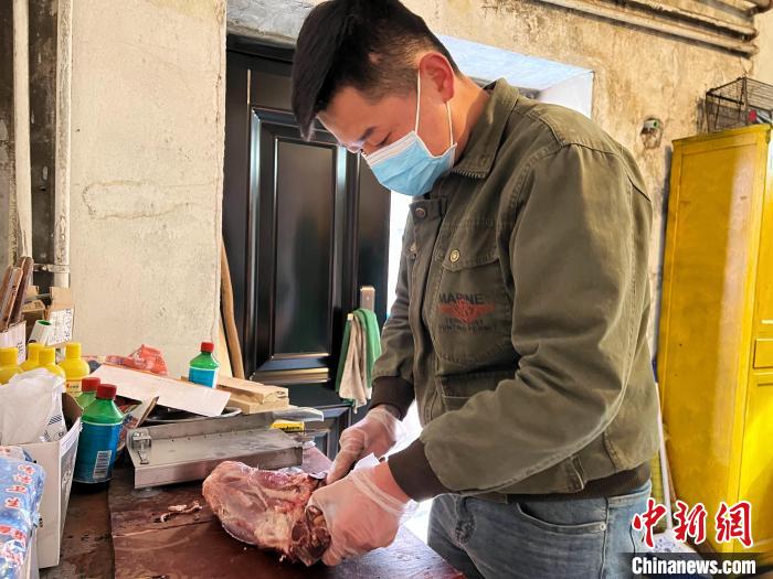 圖為雪豹“奶爸”史壽軍正在準(zhǔn)備投喂雪豹的食材?！●R銘言 攝