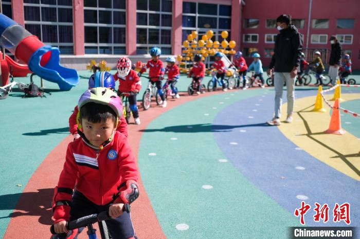 圖為拉薩市實驗幼兒園孩子們在教練的指導(dǎo)下練習(xí)滑步車?！『闻罾?攝