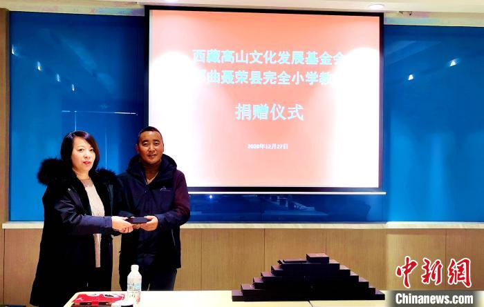 圖為西藏高山文化發(fā)展基金會理事長溫麗向聶榮縣完全小學負責人捐助儀器。　于賓 攝