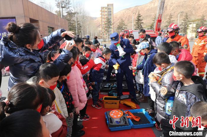 圖為小朋友們聽消防員講解消防器材。　楊龍建 攝