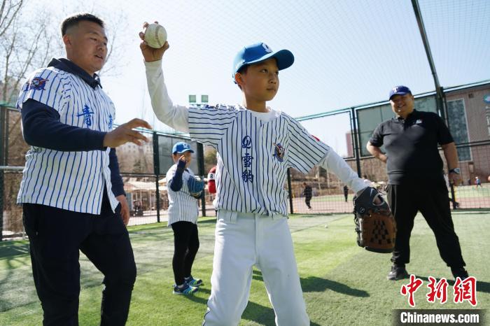 圖為教練指導(dǎo)小棒球手?jǐn)S球技術(shù)?！●R銘言 攝