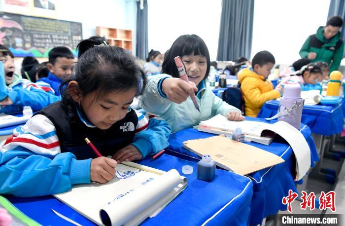 3月14日，西藏拉薩市第一小學一年級六班學生白瑪朗珍(圖左)在藏語文課上書寫藏文?！±盍?攝