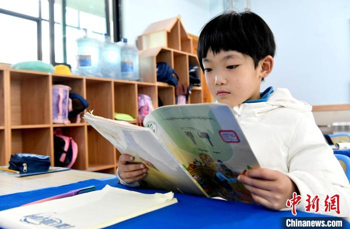 3月14日，西藏拉薩市第一小學一年級六班學生丁增樂吉在閱讀藏語課本。　李林 攝