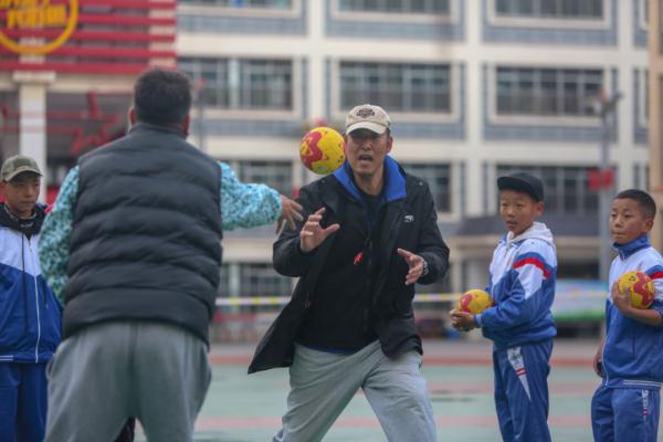 在高原上教孩子們打手球，“慢慢兒來，甭著急！”