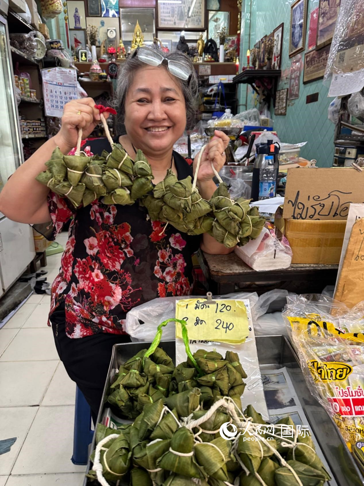 商家向顧客介紹“吉掌”（粽子的一種，一串一串，個頭較小）。人民網記者 簡承淵攝