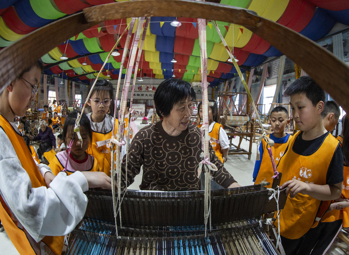5月1日，在山西省永濟市開張鎮(zhèn)東開張村的惠暢土布文化園，土布制作技師教游客織布技藝。 來源：人民圖片網(wǎng)