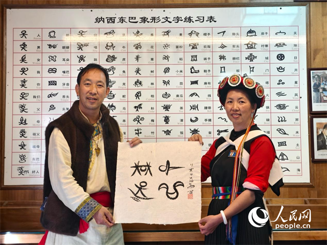 人民網(wǎng)“行進中國”云南調(diào)研采訪團走進麗江，和閏元現(xiàn)場用東巴文寫下“行進中國”。人民網(wǎng)記者 符皓攝