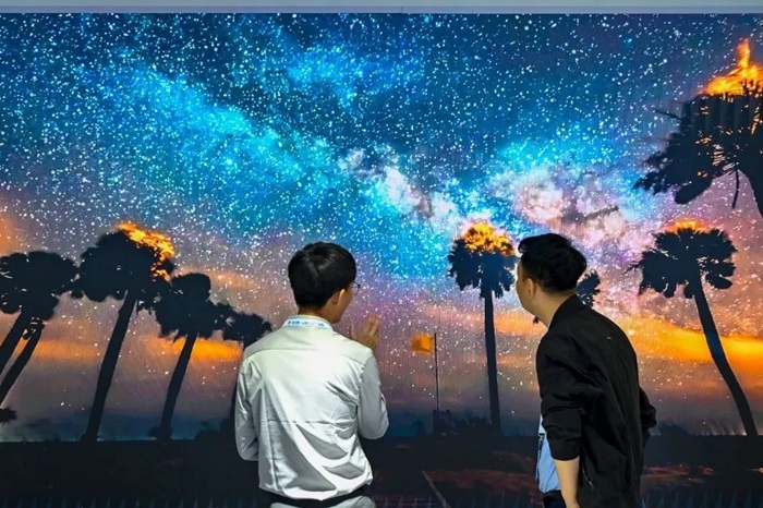 長春光博會希達電子展區(qū)，一位工作人員正在給一位觀眾講解。（長春新區(qū)供圖）
