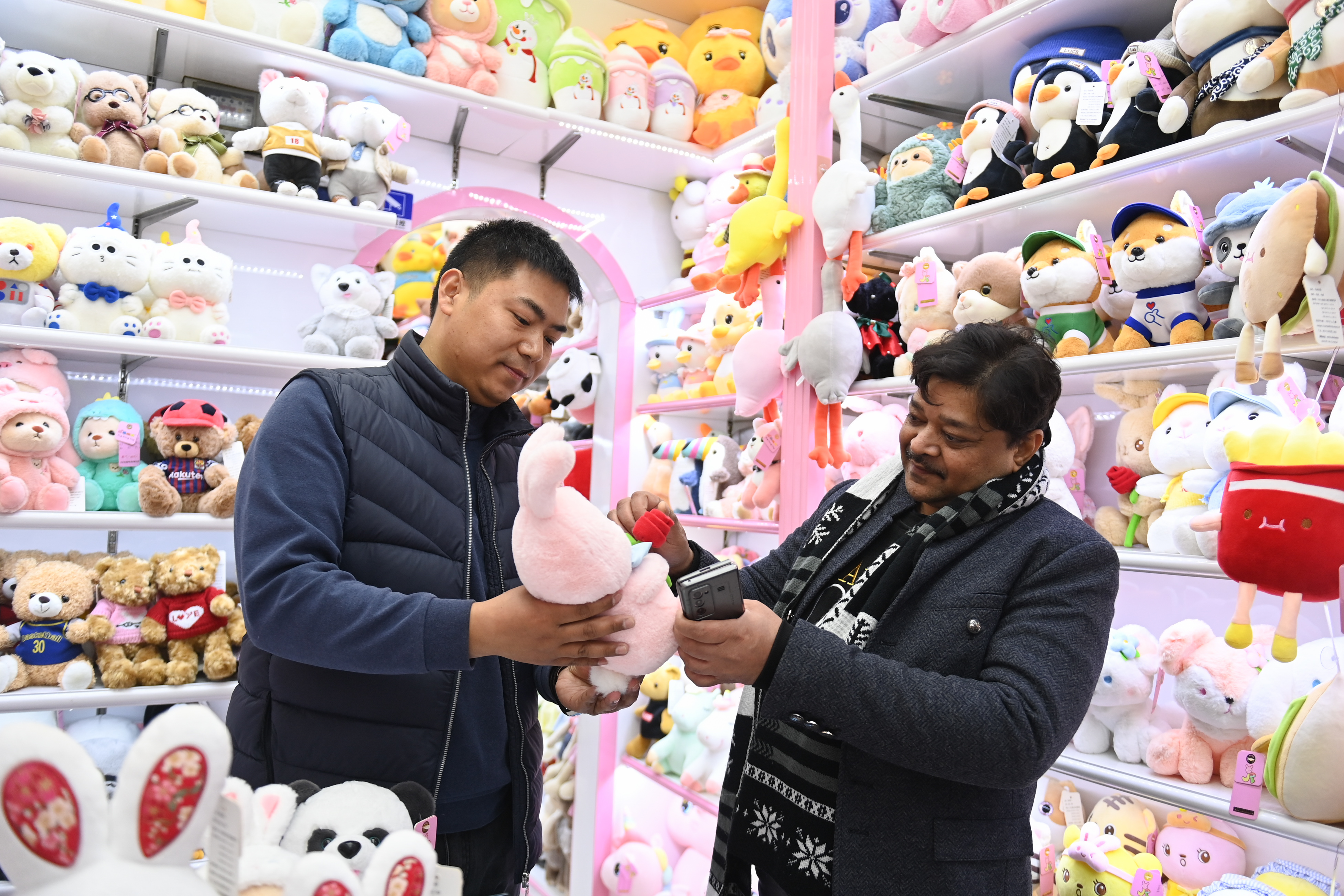 2023年2月2日，來(lái)自印度的客商（右）在義烏國(guó)際商貿(mào)城的一家玩具店鋪內(nèi)選購(gòu)。