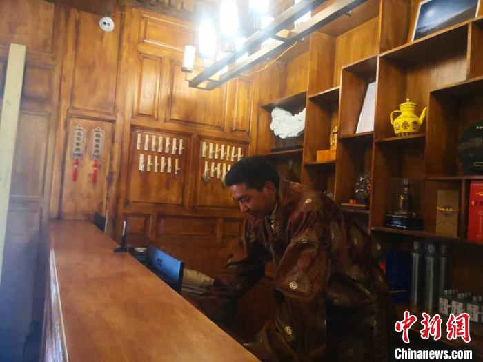 圖為桑杰才讓用電腦處理財務(wù)。　史靜靜 攝