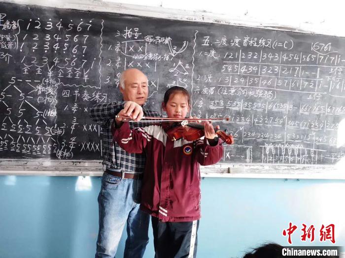 圖為趙興洲教學(xué)生拉小提琴。受訪者提供
